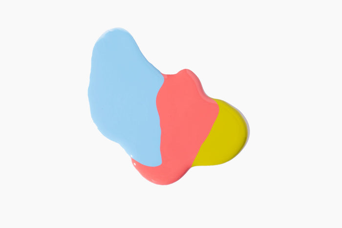 Three paint blobs overlap on a white background: blue on the left, red in the middle, and yellow on the right. Their slight blending evokes the vibrant hues of Terra Beauty Bars salon-quality vegan nail polish from the Good Vibes Kit.