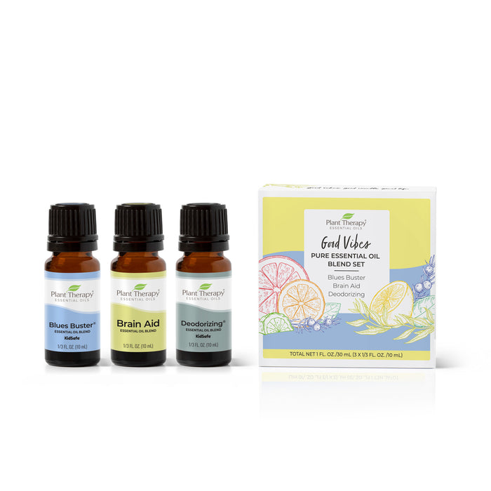 Three essential oil bottles labeled Blues Buster Essential Oil, Brain Aid, and Deodorizing Essential Oil are next to a box with citrus and floral illustrations named Good Vibes Pure Essential Oil Blend Set by Plant Therapy, ideal for aromatherapy.
