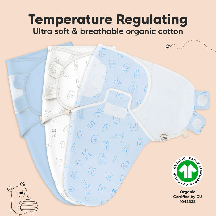 Three baby swaddle blankets are displayed against a beige background. The swaddles feature different designs in shades of blue and white with alphabet patterns. Text highlights their temperature-regulating, ultra-soft, breathable organic cotton material.