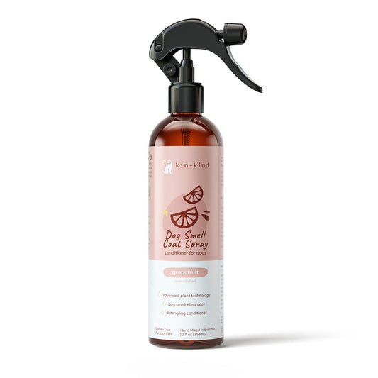 The kin+kind Grapefruit Coat Spray for Dog Smells features a black spray nozzle and a pink label with citrus graphics. It naturally neutralizes odors, conditions, and detangles dog fur using advanced plant technology. The bottle contains 12 fl oz (354 mL).