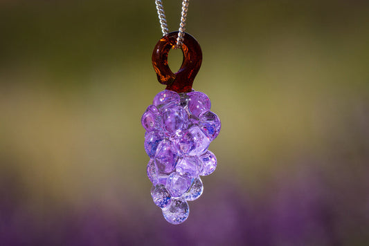 Glass grape cluster pendant infused with cremation ash, purple bead grapes hanging in a cluster on a silver chain.