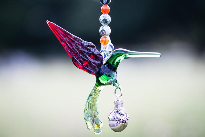 Green and red glass hummingbird with beaded chain and a silver keepsake urn pendant