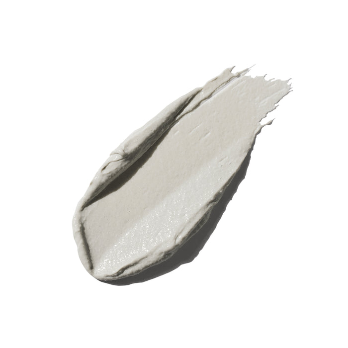 A smooth, light gray smear of Ursa Major’s Green Slate Mineral Polish is artfully spread on a white background, hinting at its mineral-rich formula and natural exfoliants that gently re-texturize skin.