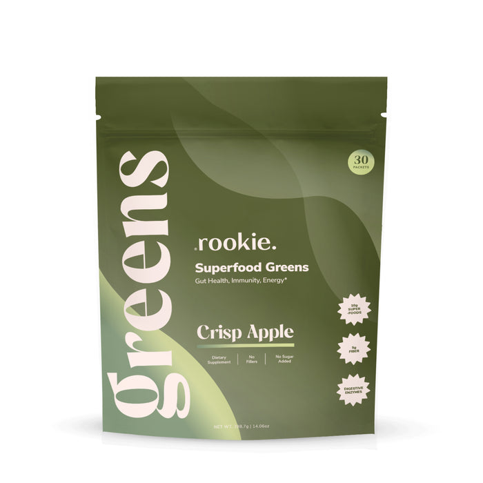 A green resealable pouch labeled Rookie Wellness Greens + Superfood, Crisp Apple flavor, features bold "greens" text, icons for Dietary Supplement, No Fillers, No Sugar Added, 30 Servings—supports gut health with daily greens.