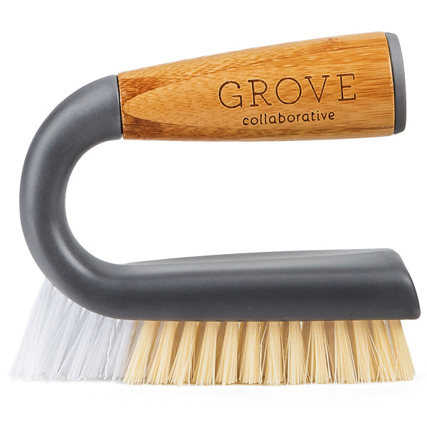 The Grunge Buster Grout & Tile Brush by Grove Co. features an angled design with a wooden handle engraved Grove Collaborative, a dark plastic body, and tough white and beige bristles, ideal for cleaning tiles.