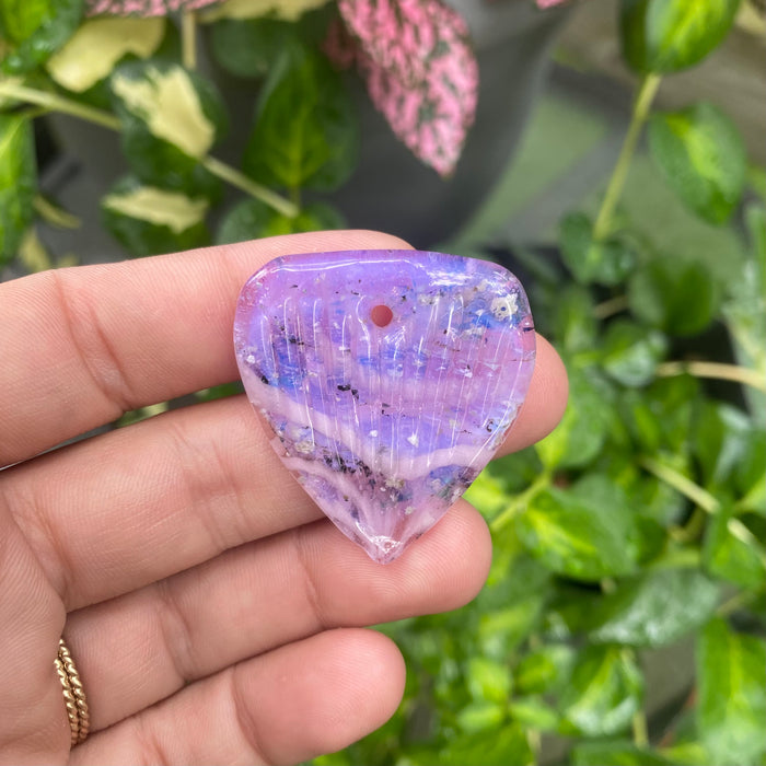 guitar pick with cremation ash lilac in hand