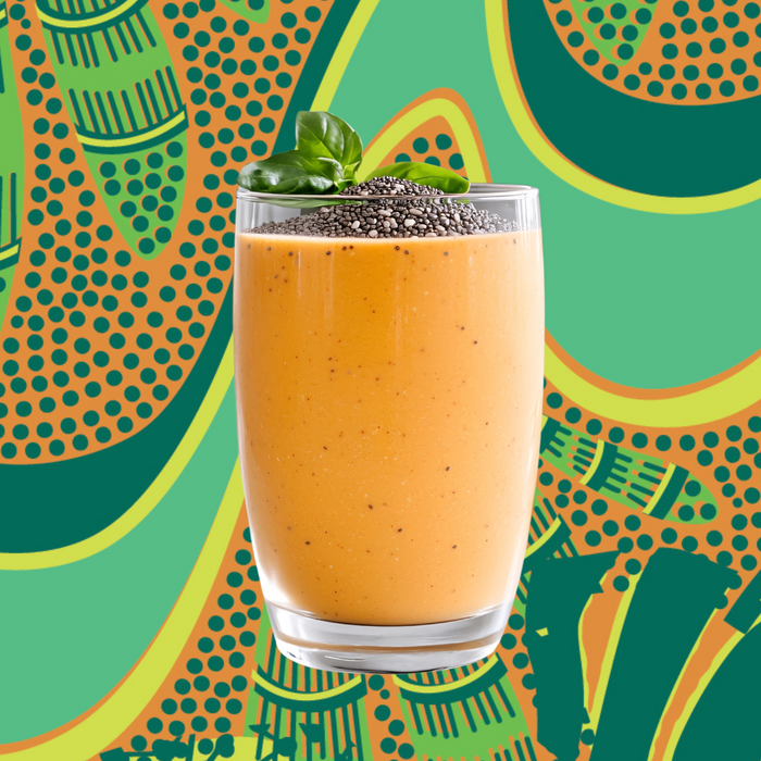 A glass of Gut Bliss Organic Superfood Blend by Kuli Kuli Foods, topped with chia seeds and basil leaves, stands against a vibrant abstract green, yellow, and orange background.