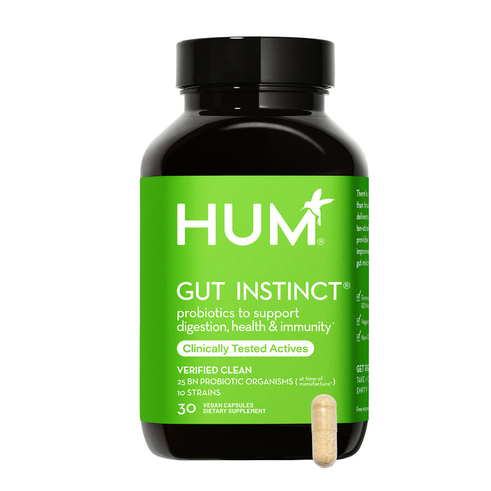 A black bottle of HUM Nutritions Gut Instinct Probiotics features a green label promoting benefits for digestion, health, and immunity with Clinically Tested Actives. A single capsule beside it highlights its potent probiotic blend.