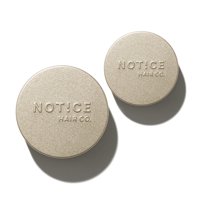 Against a light background, two round, beige containers with NOT!CE Hair Co embossed on the lids cast soft shadows. These sleek Hair Bar Travel Tins showcase a zero-waste design, ideal for eco-conscious consumers.