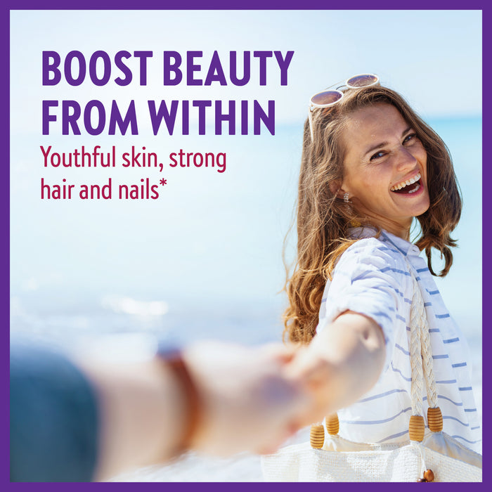 A smiling woman with long brown hair, wearing a striped shirt and sunglasses on her head, holds hands with someone. The ocean is in the background. Text reads: "Boost beauty from within. Youthful skin, strong hair and nails*".