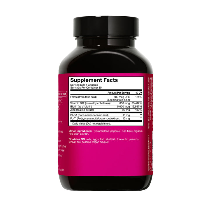 The Hair Strong capsules by HUM Nutrition come in a black bottle with a pink label displaying vital supplement facts for hair growth, including folate, vitamin B12, biotin, and PABA. The stylish packaging is photographed against a white background.