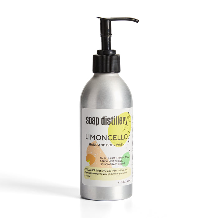 An 8 fl oz aluminum bottle of Soap Distillery Hand + Body Wash with a reusable black pump features citrus graphics, highlighting lemon peel, bergamot, and lemongrass scents.