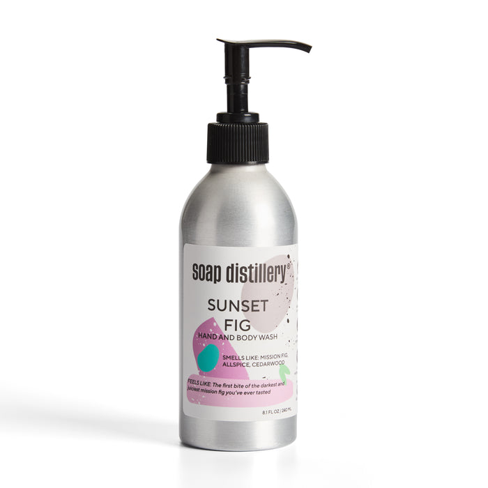 Soap Distillerys Hand + Body Wash in a sleek aluminum bottle features a reusable pump. The minimalist label, adorned with purple and green fig accents, enhances its refined look.