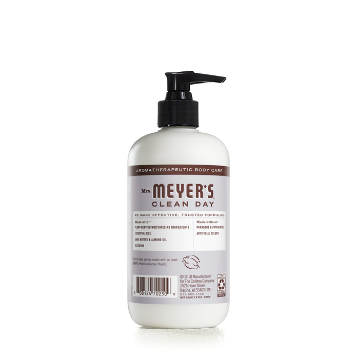 A white bottle of Mrs. Meyers hand lotion with a black pump is set against a plain white background. The label boasts aromatherapeutic body care featuring enriching ingredients like almond oil, olive oil, and aloe vera for gentle skin care.