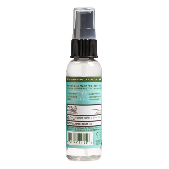 Mrs. Meyers elegantly presents a small transparent hand sanitizer spray bottle with a black cap, adorned with a light blue label highlighting its aromatherapeutic body care qualities, natural ingredients, and 62% ethyl alcohol content.