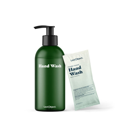 In a simple white setting, a green pump bottle labeled Hand Wash stands next to a light blue sachet of Powder Based Hand Wash from the LastObject Hand Wash Starter Set. Ideal for sensitive skin, these products use natural sugars for gentle cleansing.