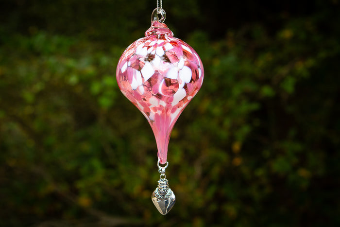 Pink mosaic glass teardrop ornament hanging from a ring with a silver ornate keepsake urn pendant