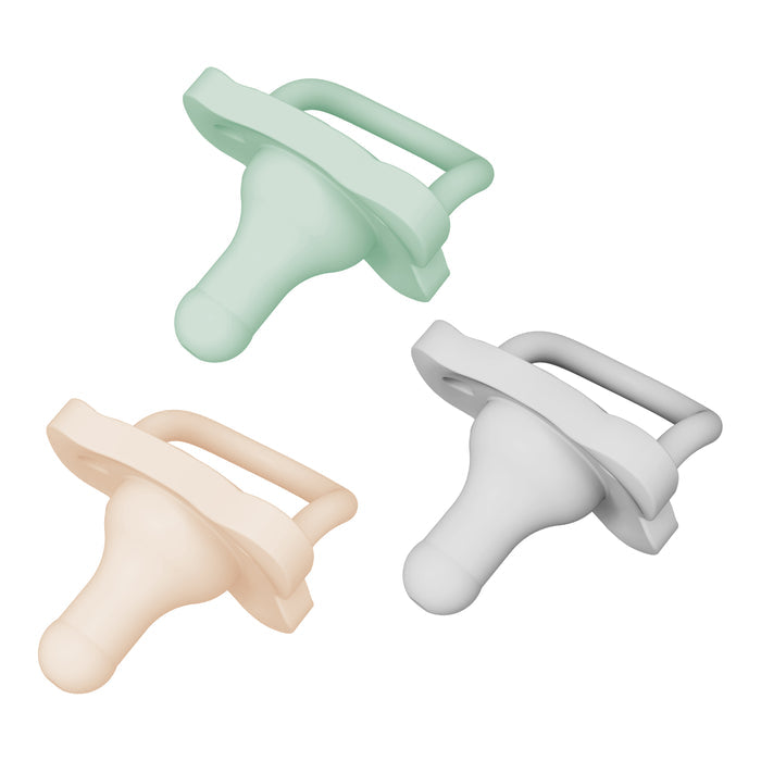 Dr. Browns HappyPaci 100% Silicone Pacifiers for 0-6 months are showcased in pastel green, cream, and grey. These infant pacifiers feature a bulbous design with flat rectangular handles and butterfly-shaped shields. Theyre easy to clean and arranged diagonally.