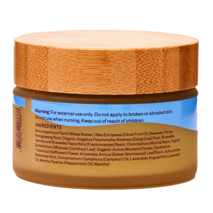 The WTHN Head to Toe Muscle Rub is an organic salve in a jar with a wooden lid. It features a label listing ingredients such as shea butter, olive oil, beeswax, and botanical extracts. Warnings include external use only and keeping it out of childrens reach.