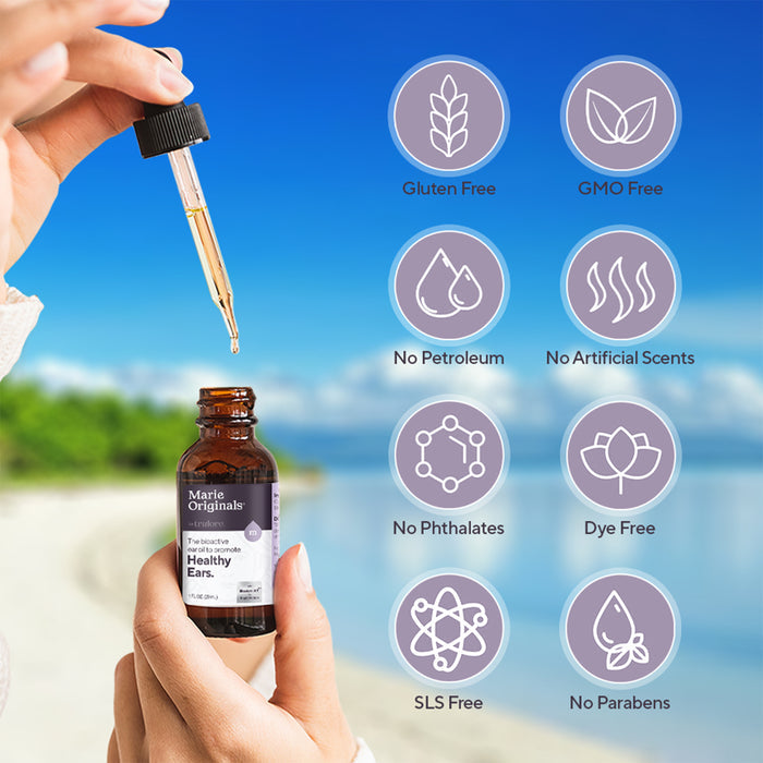 A hand holds a dropper above a bottle of Marie Originals Healthy Ear Oil. The beach scene and icons highlight its gentle, chemical-free formula—perfect for supporting ear health and easing discomfort.