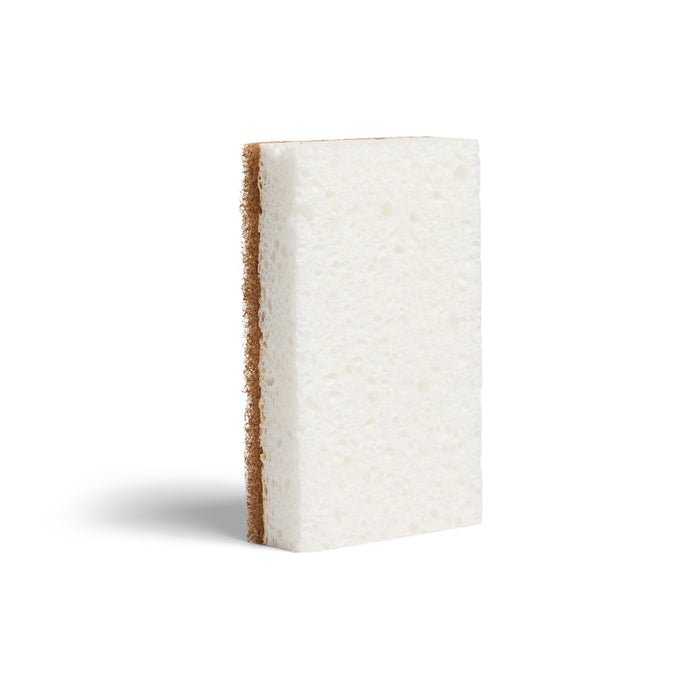The Grove Co. Heavy Duty Agave Scrubber Sponge is rectangular, featuring a soft white side and a rough brown scrubbing side, shown upright on a white background.