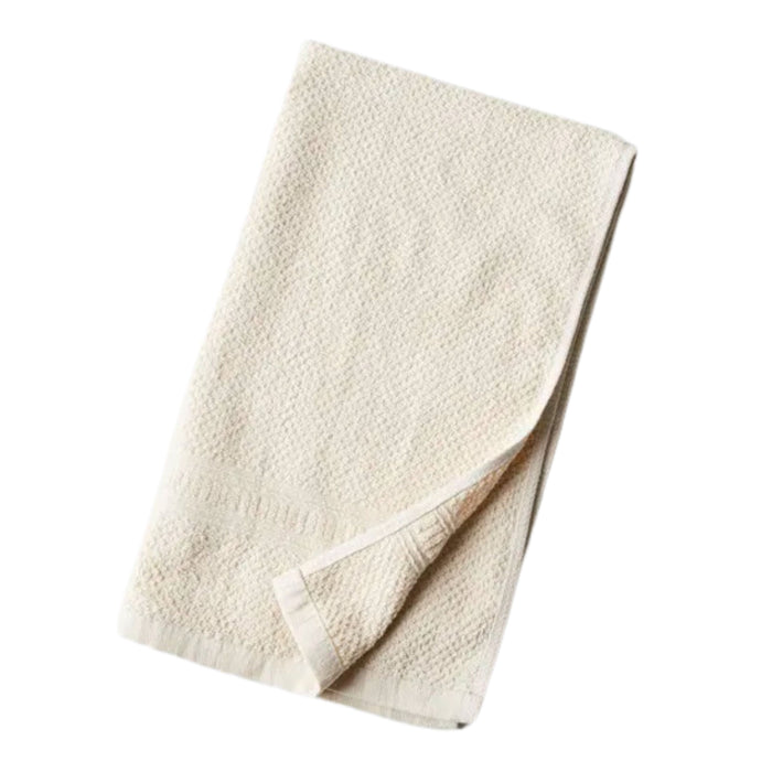 The Anact Hemp and Organic Cotton Hand Towel, in off-white with a textured pattern, is neatly folded against a plain white background.