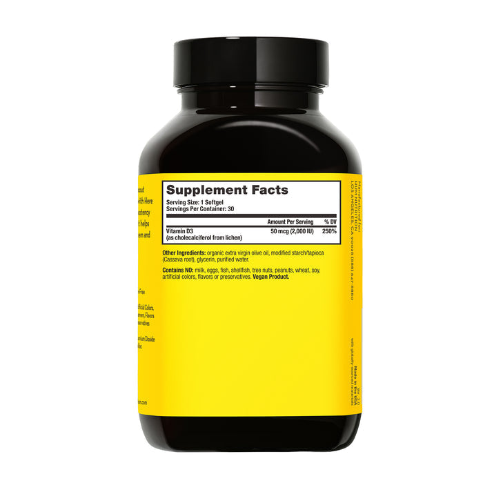 The black bottle of Here Comes The Sun by HUM Nutrition displays supplement facts with 50 mcg (2000 IU) vegan Vitamin D3 per serving, featuring organic virgin olive oil and vegetable cellulose. It supports the immune system and is vegan-friendly.