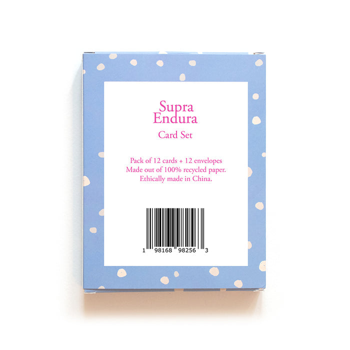 The Supra Endura Holiday Cards - Dog set features a Dachshund Holiday Card design, perfect for dog lovers. The blue box with white polka dots holds 12 recycled paper cards and envelopes, ethically made in China, with a barcode below the text.