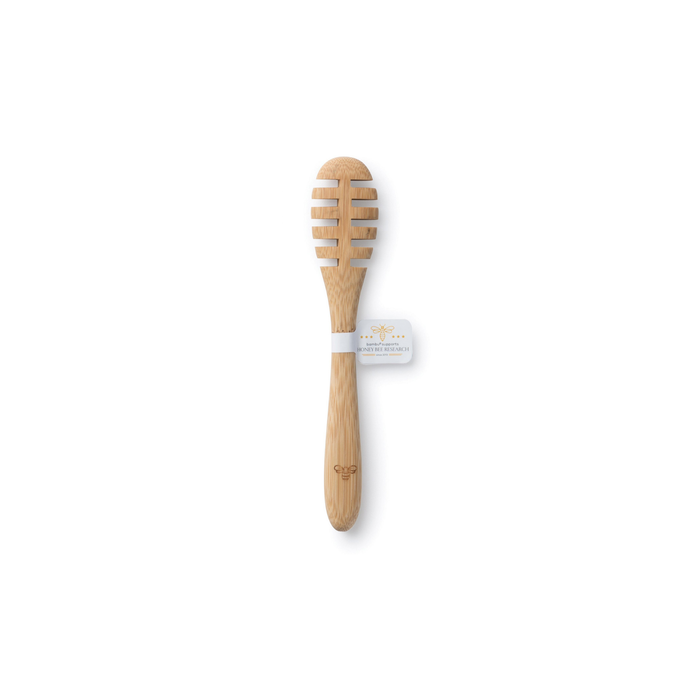 A Bambu Honey Dipper made from eco-friendly bamboo, featuring a long handle and grooved head, is set against a white background with a tag that highlights its sustainable craftsmanship.