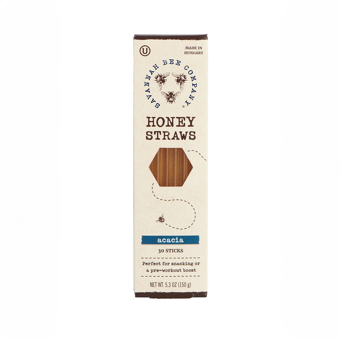 A Savannah Bee Company box of Honey Straws is shown, containing 30 acacia honey sticks. The BPA-free off-white package has a honeycomb cutout displaying the straws and a delightful bee illustration.