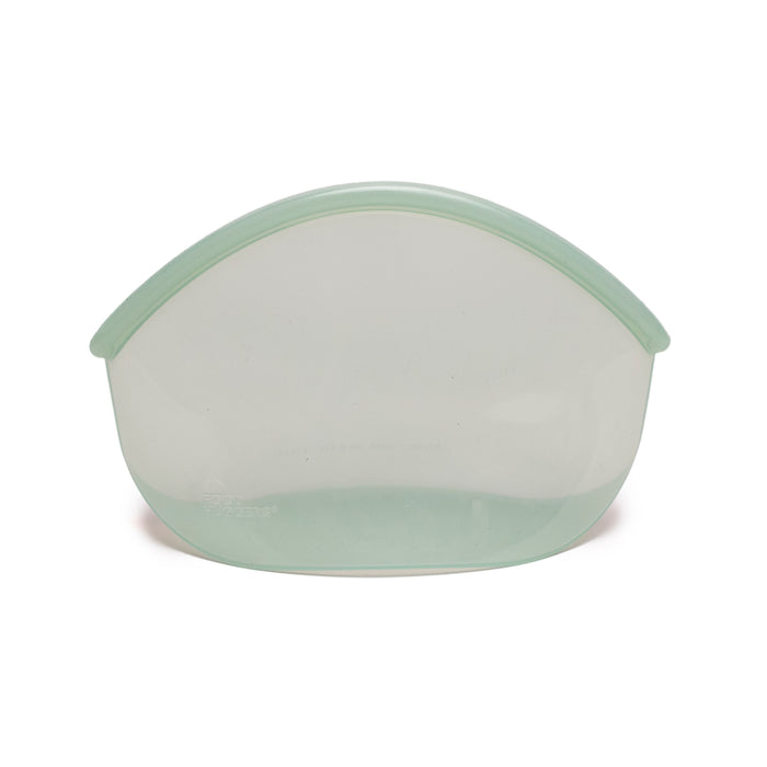 The Hugger Bag by Food Huggers is a light green, semi-transparent silicone pouch that stands upright on a flat bottom with a rounded top. Designed for food storage, its microwave safe and easy to clean, offering convenient kitchen essentials against a plain white background.