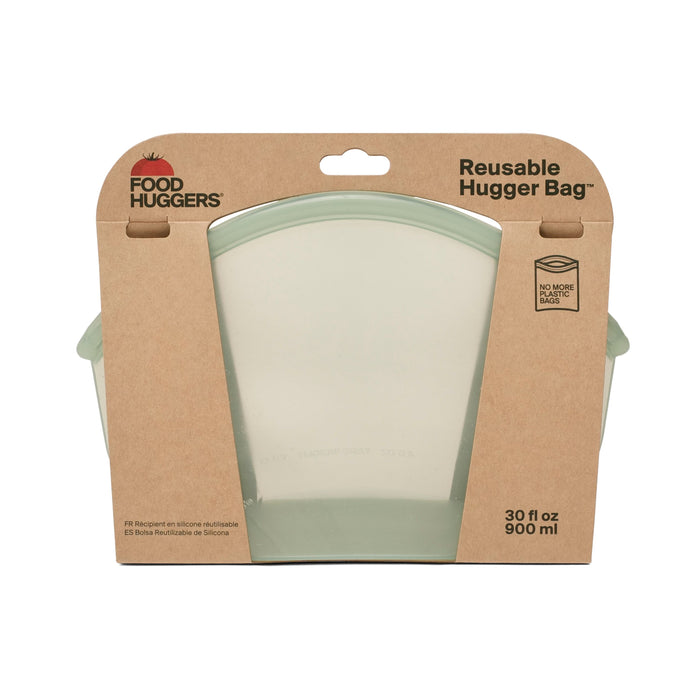 The Hugger Bag by Food Huggers is a translucent, green-tinted reusable bag with a 30 fl oz (900 ml) capacity. Its microwave and dishwasher safe and features an eco-friendly design with Food Huggers and No More Bags logos for easy cleaning.