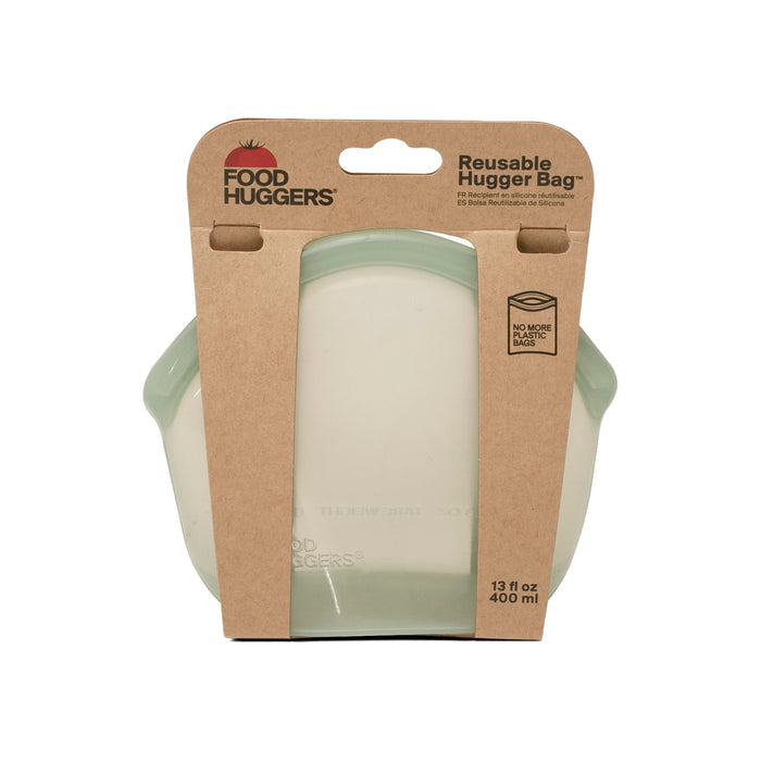 The Food Huggers Hugger Bag features a transparent container with a light-green tint. Its cardboard label states 13 fl oz/400 ml, touts the bag as a sustainable alternative to plastic bags, and mentions its dishwasher safe for easy cleaning.