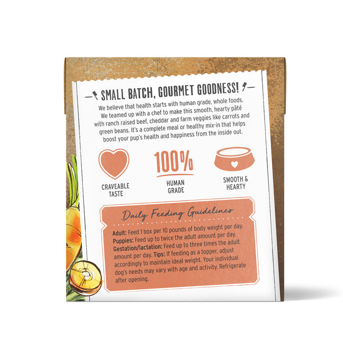 The image displays the back of The Honest Kitchens Beef, Cheddar & Veggies Wet Dog Food package, highlighting Small Batch, Gourmet Goodness, Human Grade, and 100% nutritious benefits. Feeding guidelines for adults and puppies are provided alongside images of carrots and peas.