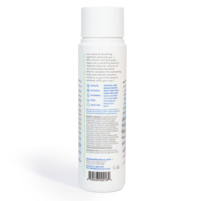 The Seaweed Bath Cos Hydrating Cleansing Body Wash comes in a white cylindrical bottle with a label detailing its ingredients and benefits, such as antioxidant-rich algae. It highlights being gluten-free, sulfate-free, vegan, and cruelty-free. The bottle is set against a white background.
