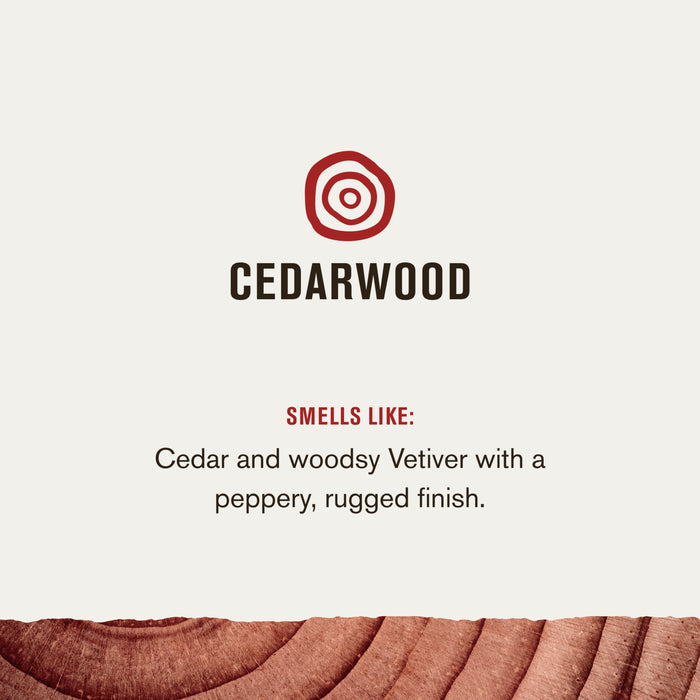 The image displays Cedarwood with a logo above, and includes text: Smells like: Cedar and woodsy Vetiver with a peppery, rugged finish. Its infused with soothing Aloe Vera, set against a rich wood-textured background. Product is 3-in-1 All Over Wash by Every Man Jack.