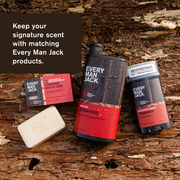 Every Man Jack cedarwood-scented grooming products, including the 3-in-1 All Over Wash with coconut-derived surfactants for a natural cleanse, are displayed on wood. Text: Maintain your signature scent with matching Every Man Jack items.