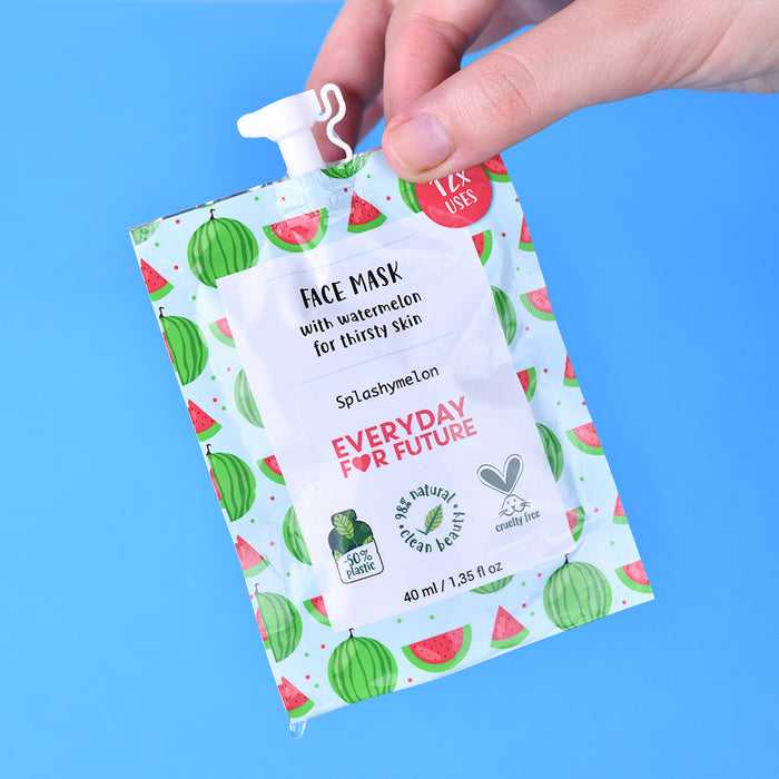 A hand holds a pouch of Everyday For Futures Hydrating Watermelon Face Mask against a blue backdrop. Vibrant watermelon designs embellish the packaging, which boasts revitalizing skincare for thirsty skin with 12 uses, natural ingredients, and a vegan-friendly, eco-conscious ethos.