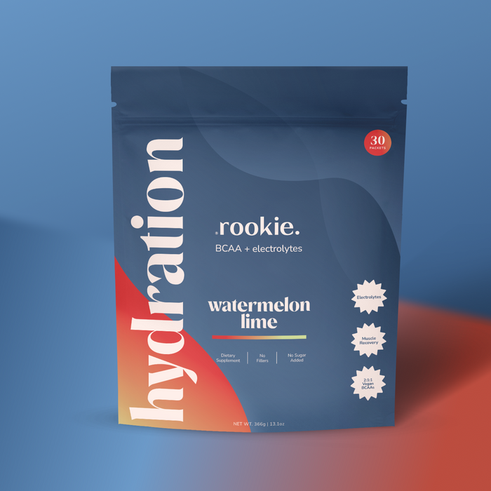 A blue and red pouch labeled “hydration” features Rookie Wellness Hydration Support + Electrolytes with BCAA in watermelon lime flavor. The package highlights 30 servings, no sugar, and three white starburst icons showing its benefits.
