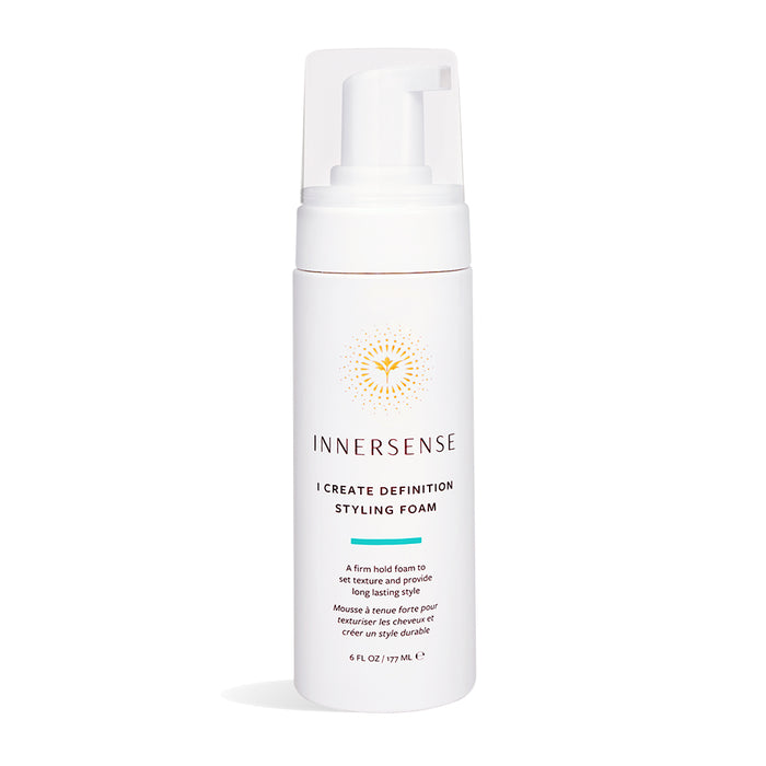 The Innersense Organic Beauty I Create Definition Styling Foam comes in a white 6 fl oz (177 mL) bottle with a pump dispenser and a gold circular design near the top. Infused with aloe leaf juice, it offers firm hold for long-lasting, frizz-free curls.