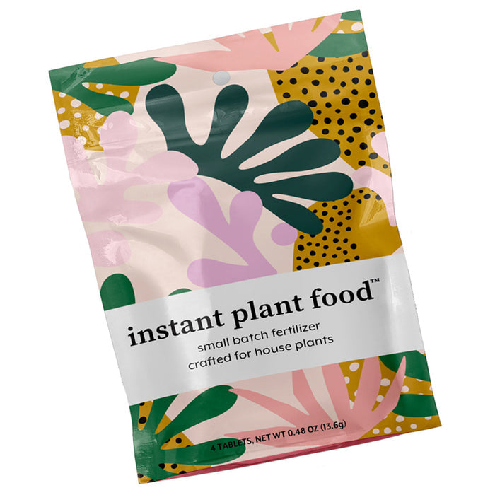 The vibrant packaging for Instant Plant Food Tablets by Instant Plant Food is ideal for indoor plants, featuring abstract green, pink, and yellow leafy patterns with polka dots. The label highlights it as a small batch fertilizer crafted for houseplants.