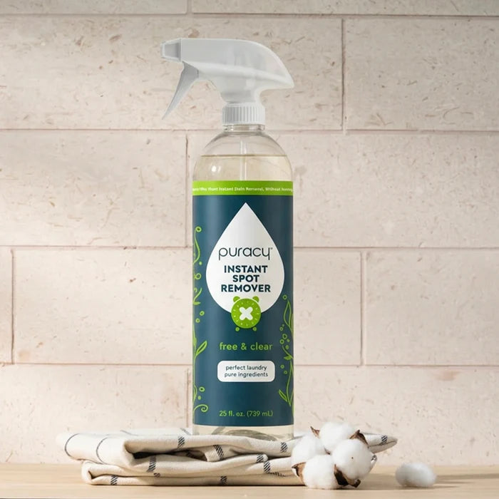A bottle of Instant Spot Remover on folded towels and cotton against a stone background.