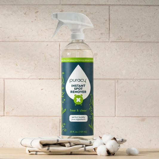 A bottle of Instant Spot Remover on folded towels and cotton against a stone background.