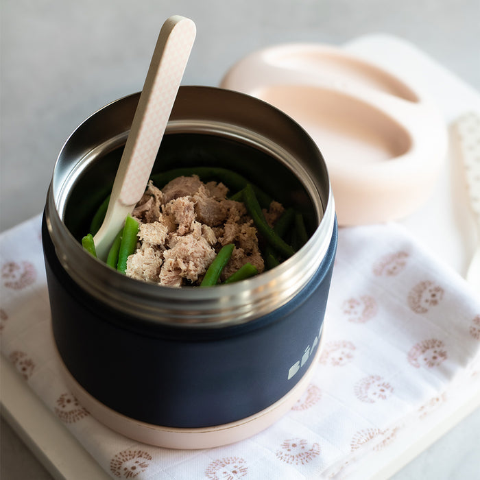 The BEABA Insulated Stainless Steel, Kid Friendly Food Container Jar in black and beige holds tuna and green beans. A white spoon sits nearby on a patterned cloth, with the lid beside it. Make mealtime stylish and temperature-controlled with this chic accessory.