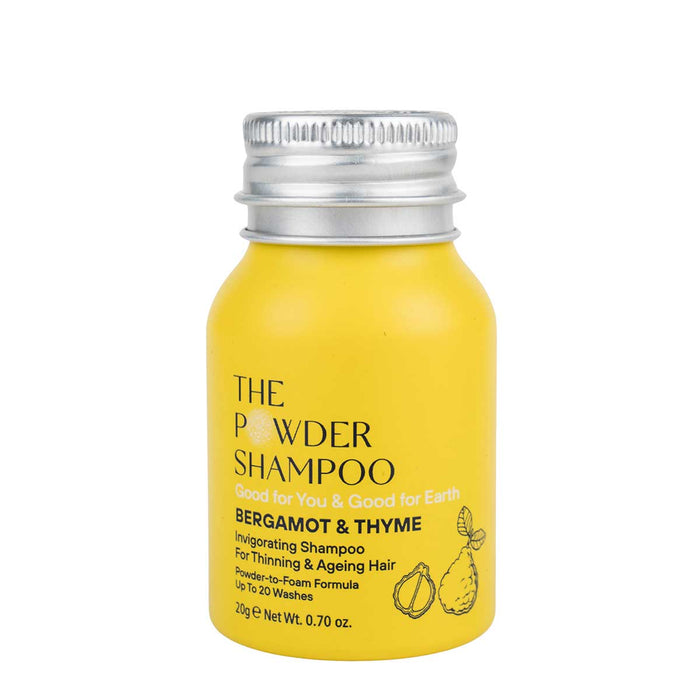 A small yellow recyclable aluminum bottle with a silver cap is labeled The Powder Shampoo. It contains Invigorating & Stimulating Powder Shampoo with Bergamot & Thyme, ideal for thinning and aging hair. Each 20g bottle offers 10-20 washes, promoting hair growth.