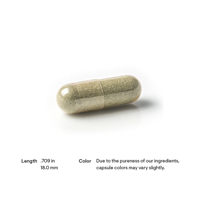 A single capsule with a light grayish-green powder inside, displayed on a white background. Text below describes the capsule's length as 0.709 inches (18.0 mm) and notes color variations due to ingredient purity.