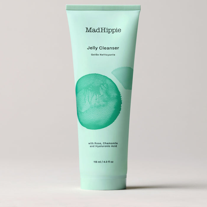 A 118 ml (4.0 fl oz) tube of Mad Hippie Jelly Cleanser, showcased against a neutral backdrop, has an aqua design with green abstract elements and offers hydration with antioxidants like rose, chamomile, and hyaluronic acid.