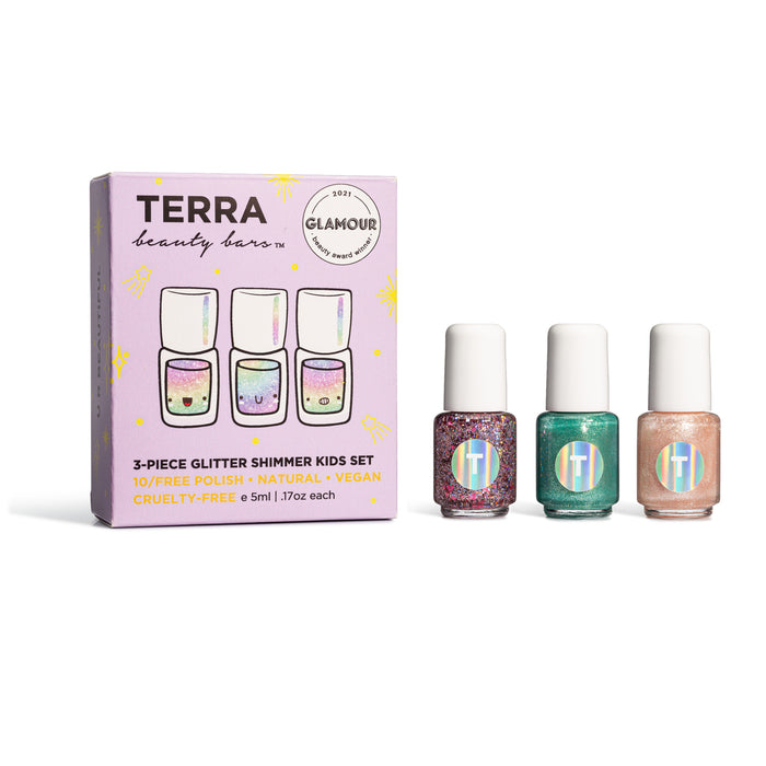 The Kids 3-Piece Glitter Shimmer Nail Collection by Terra Beauty Bars is showcased. It includes a pastel box with colorful, printed text and three small, cruelty-free nail lacquer bottles in red glitter, teal, and pink shimmer.