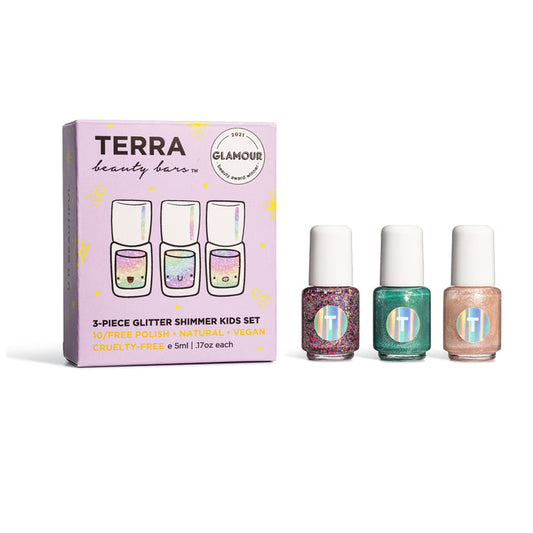 The Kids 3-Piece Glitter Shimmer Nail Collection by Terra Beauty Bars is showcased. It includes a pastel box with colorful, printed text and three small, cruelty-free nail lacquer bottles in red glitter, teal, and pink shimmer.