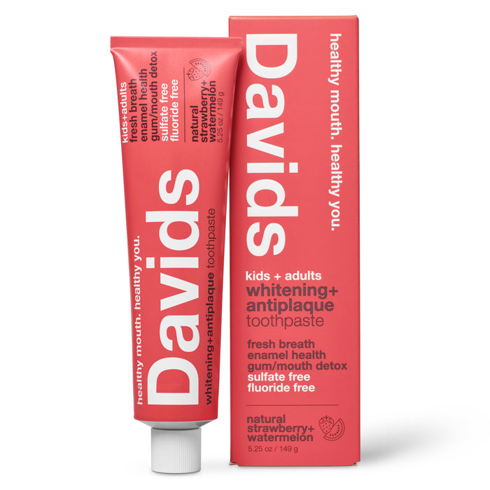 A tube and box of Davids Kids + Adults Premium Toothpaste in natural strawberry and watermelon flavor, featuring fluoride-free whitening and antiplaque benefits, and packaged in eye-catching pink for both kids and adults.